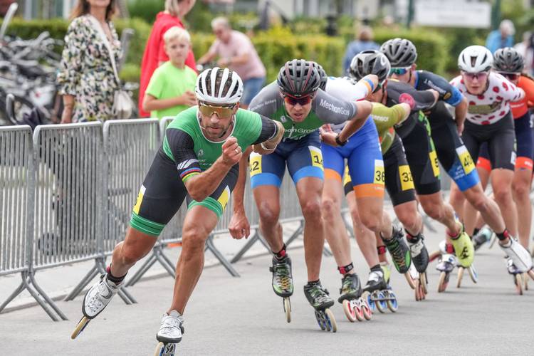 Crispijn Ariëns voert het peloton aan in Heerhugowaard, in de achtergrond kijkt zijn zoon toe.