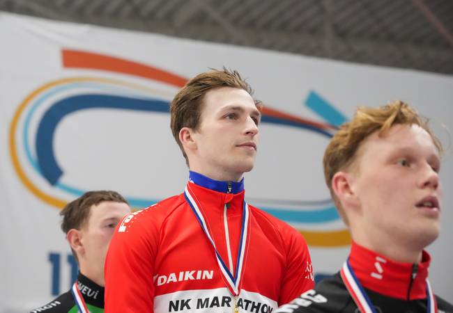 Luc ter Haar luistert naar het Wilhelmus na zijn overwinning op het Daikin NK Marathon